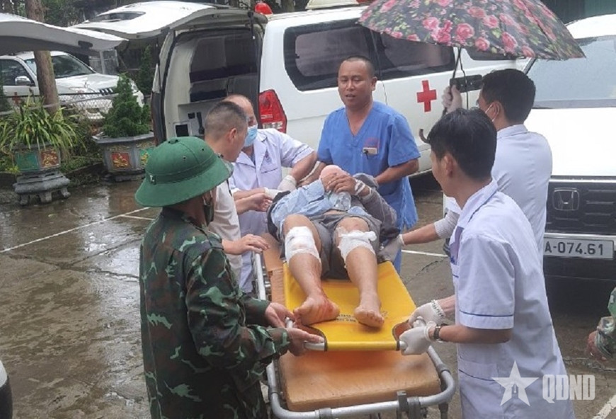 Khu vực lán trại bị hư hỏng do vụ sạt lở (ảnh trái) và nạn nhân được lực lượng chức năng đưa đi cấp cứu (ảnh phải - ảnh: Báo Quân đội Nhân dân) Khu vực lán trại bị hư hỏng do vụ sạt lở (ảnh trái) và nạn nhân được lực lượng chức năng đưa đi cấp cứu (ảnh phải - ảnh: Báo Quân đội Nhân dân)