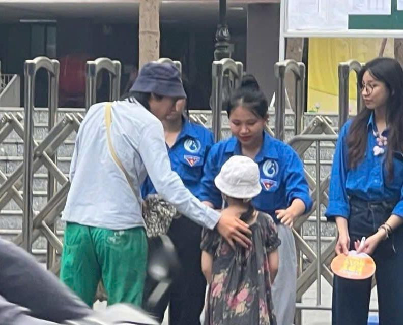 Hình ảnh anh trai đưa em gái đến điểm thi vào lớp 10 chuyên, nhờ tình nguyện viên trông giúp để vào phòng thi.