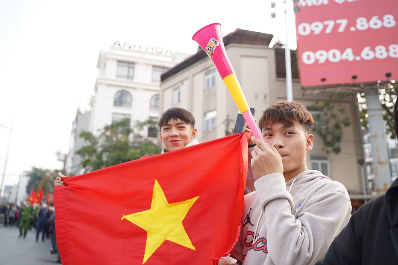 Người dân đứng 2 bên đường vẫy cờ, hò reo chào đón đoàn xe đi qua