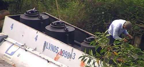 Dùng kéo cắt niêm nhựa trên nắp hầm chứa xăng. Dùng kéo cắt niêm nhựa trên nắp hầm chứa xăng