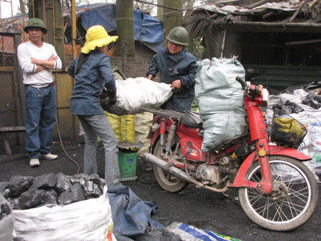Các chị cũng kiêm luôn nhiệm vụ khiêng bao than lên xe cho khách hàng mỗi khi có người đến mua