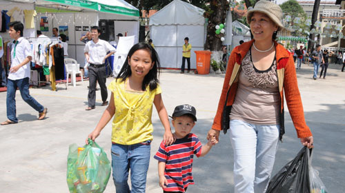 Bà Trương Thị Tường Vân - nhà ở quận Tân Bình - cùng hai con mang các loại chai lọ, hộp giấy đã qua sử dụng đến đổi lấy quà. Ảnh: Minh Đức. Bà Trương Thị Tường Vân - nhà ở quận Tân Bình - cùng hai con mang các loại chai lọ, hộp giấy đã qua sử dụng đến đổi lấy quà. Ảnh: Minh Đức