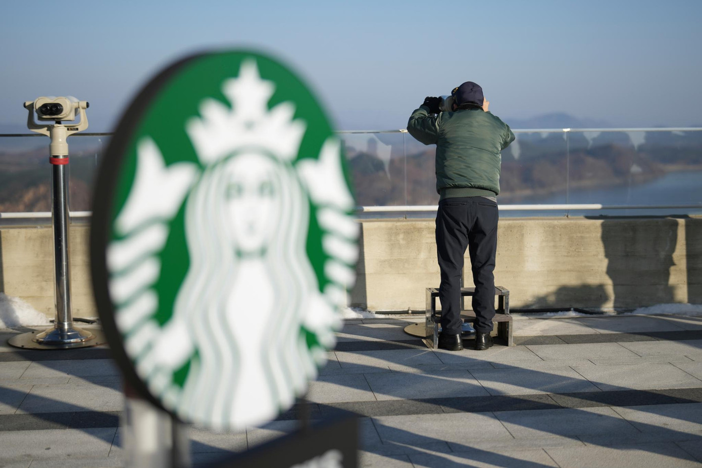 Những du khách hiếu kỳ đến Starbucks để ngắm cảnh Triều Tiên. (Ảnh: AP, Reuters)