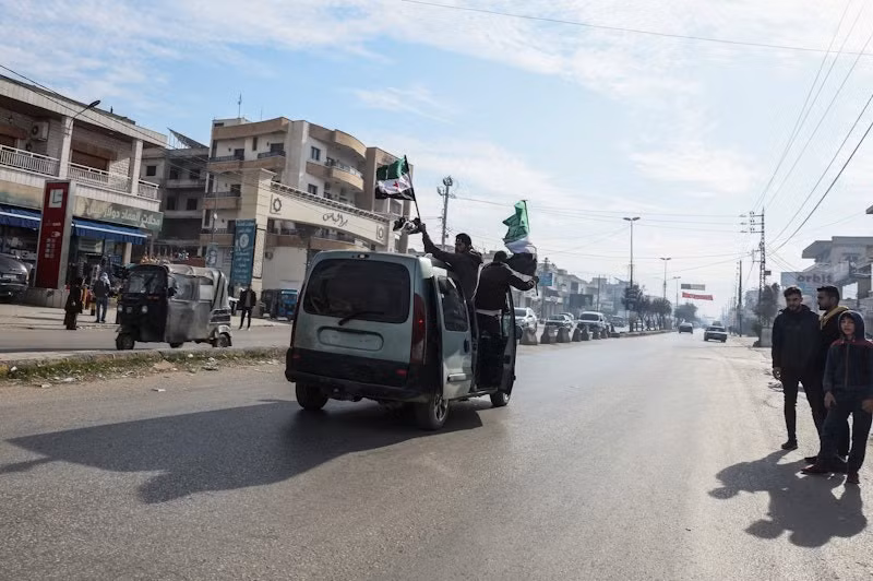 Những người cầm cờ của phe đối lập Syria ăn mừng tại Bar Elias (tỉnh Bekaa, Li-băng). (Ảnh: Reuters)