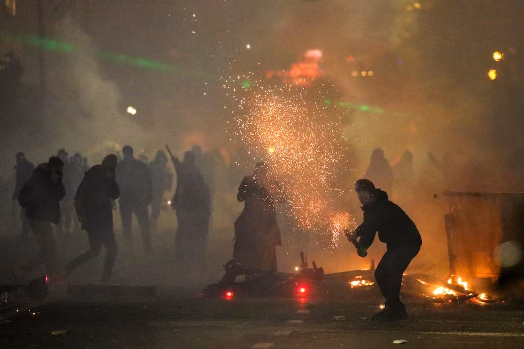 Cảnh sát khống chế người biểu tình ở Tbilisi đêm 1 rạng sáng 2/12. (Ảnh: Reuters)
