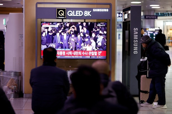 Người dân Hàn Quốc theo dõi thông tin về lệnh thiết quân luật của tổng thống. (Ảnh: Reuters)