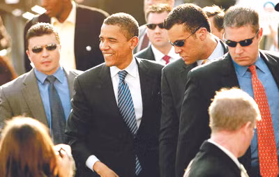 Các đặc vụ (đeo kính đen) bảo vệ Tổng thống Mỹ Barack Obama. Ảnh: Belle News