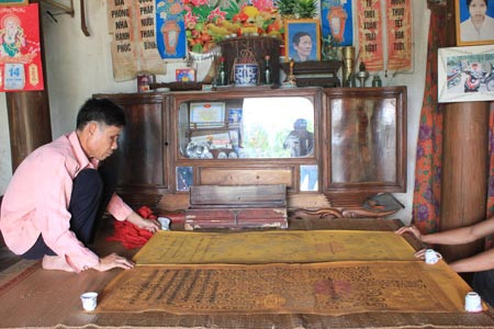 Ông Cao Văn Nguyệt cẩn trọng giở hai tấm sắc phong của vua Duy Tân. Ông Cao Văn Nguyệt cẩn trọng giở hai tấm sắc phong của vua Duy Tân