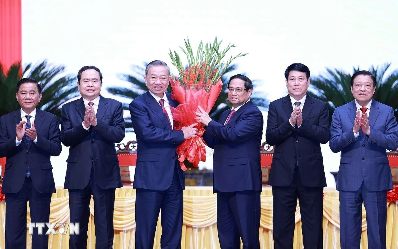 Ủy viên Bộ Chính trị, Thủ tướng Phạm Minh Chính thay mặt các đồng chí lãnh đạo chủ chốt, lãnh đạo cấp cao của Đảng, Nhà nước tặng hoa chúc mừng đồng chí Tô Lâm được bầu giữ chức Tổng Bí thư khóa XIII. (Ảnh: Dương Giang-TTXVN)