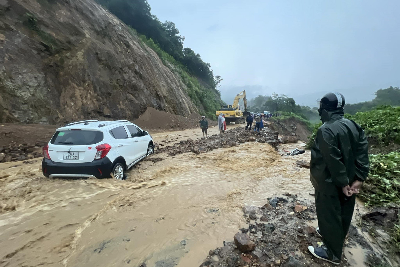 Đất đá tràn xuống mặt đường, nước chảy như suối.