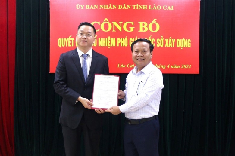 Tân Phó Giám đốc Sở Xây dựng Nguyễn Quang Bình (bên trái) nhận quyết định. Ảnh: Báo Lào Cai.