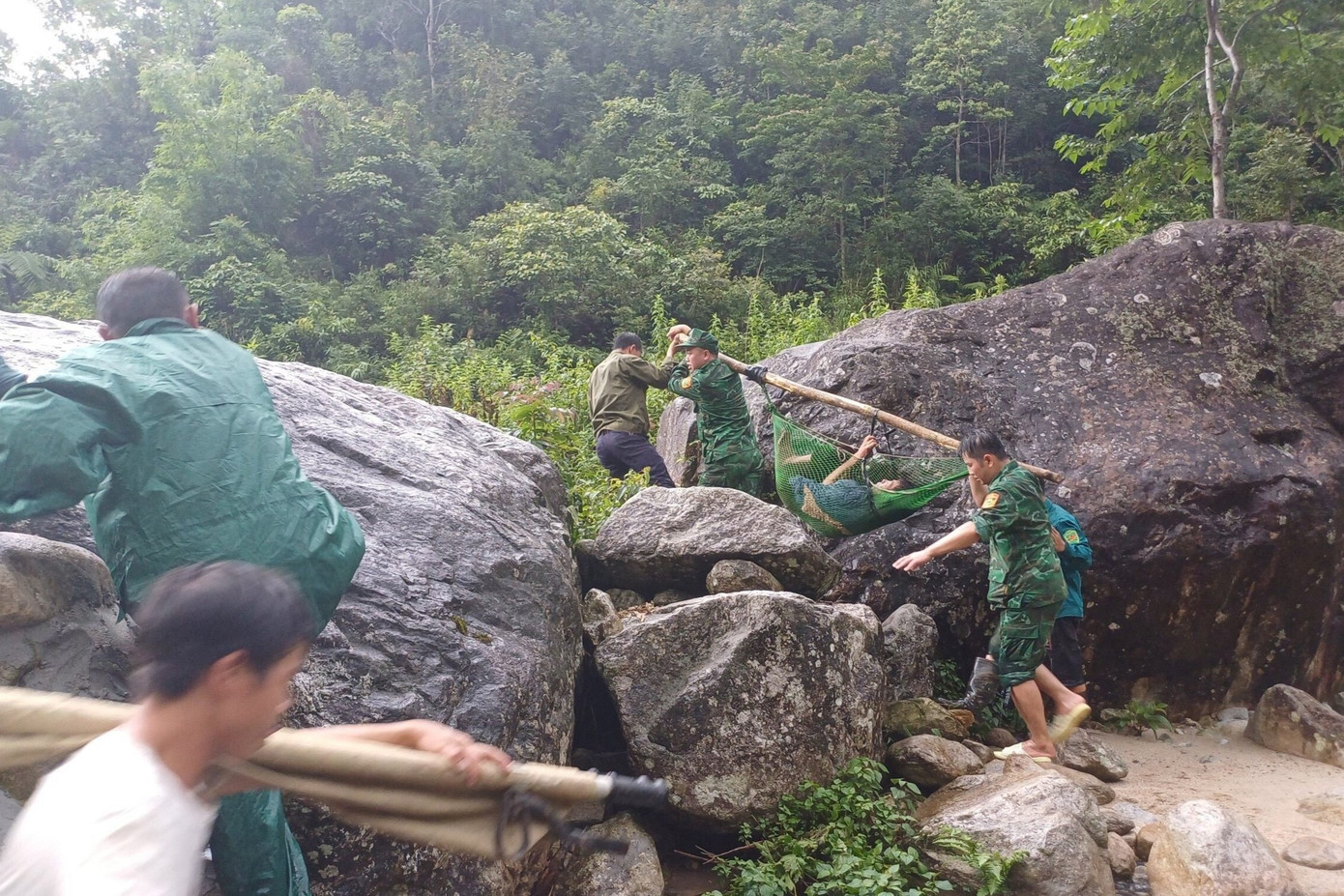 Các chiến sĩ biên phòng dùng cáng khiêng nạn nhân ra khỏi khu vực rừng sâu. Ảnh: Đức Duẩn
