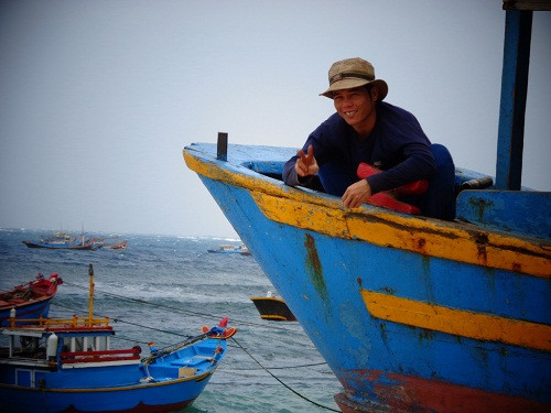 7. Ngư dân Đặng Huấn, chủ tàu câu mực 25 mã lực, tranh thủ lúc biển động để sửa chữa, gia cố lại con tàu của gia đình