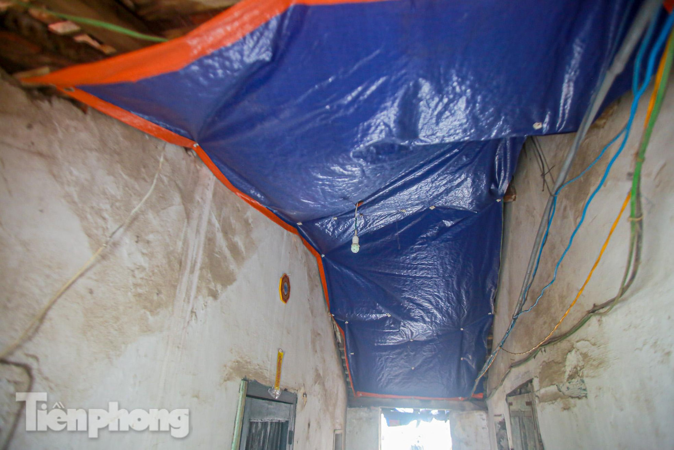 Người dân phải căng bạt để tránh dột nước từ mái ngày mưa.