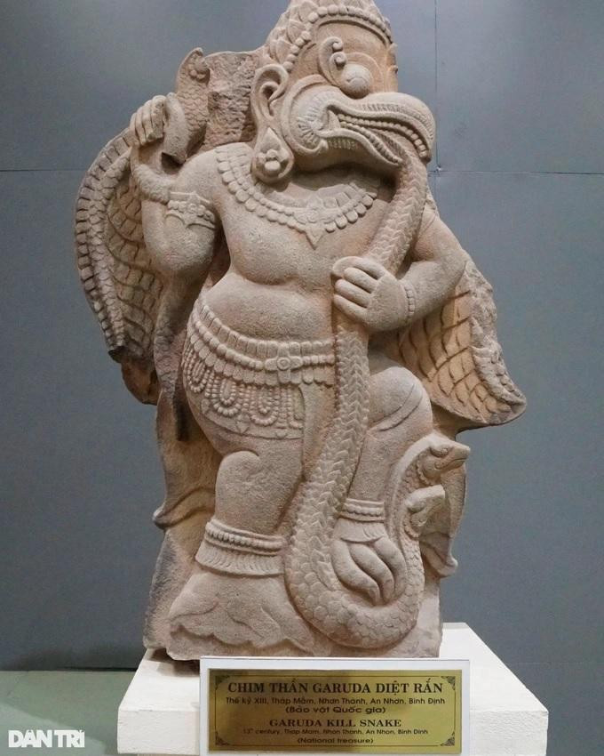 Đây là loại hình điêu khắc Champa có lẽ dùng trang trí tường tháp, hai phù điêu được đặt đối xứng nhau ở hai bên cửa tháp; mỗi phù điêu được trang trí một mặt, mặt sau để trơn. Cả hai bức phù điêu đều thể hiện hình tượng chim thần Garuda, được cách điệu nửa người nửa chim; chân đứng thẳng, xòe cánh và nhìn nghiêng về một bên; một tay cầm thân con rắn ở trước ngực, tay còn lại cũng đang tóm một con rắn khác nhỏ hơn giơ lên; miệng ngậm đuôi rắn; một chân đạp vào cổ rắn làm cho hai chiếc đầu của rắn ngẩng lên. Hình tượng thể hiện theo chủ đề Garuda- kẻ tiêu diệt các loài rắn Naga trong các câu chuyện thần thoại Ấn Độ.