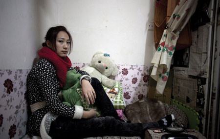 Zhao Dan trong căn phòng chỉ rộng bằng chiếc giường đơn ở Bắc Kinh, 15-1-2011. Dan làm ở một tiệm làm đẹp, được trả 350 Tệ/tháng. Giá thuê “căn phòng” này của Dan chỉ bằng 10% thu nhập hàng tháng. Cô chọn sống ở đây vì giá thuê một căn phòng bình thường cao ít nhất gấp 3 lần giá của chỗ hiện tại