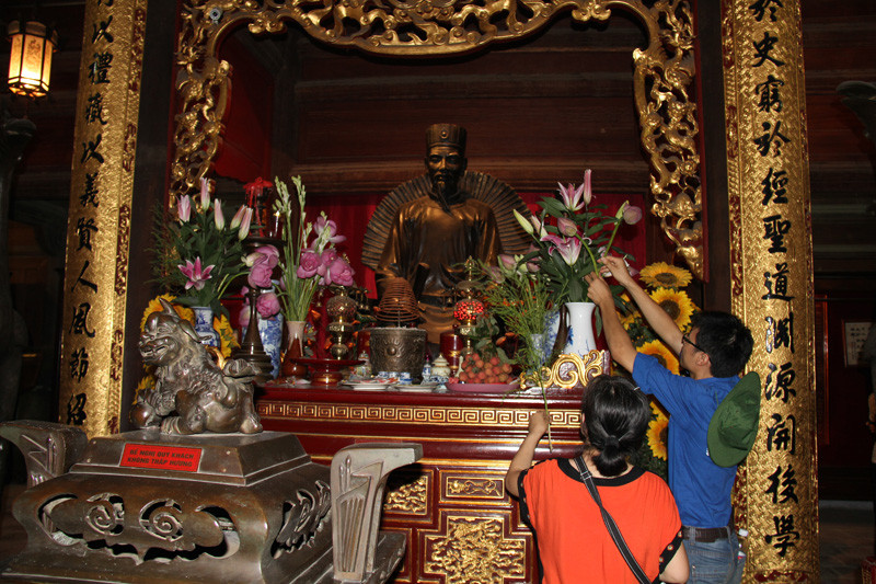 Sinh viên tình nguyện giúp du khách cắm hoa thờ. Ảnh: Trường Phong