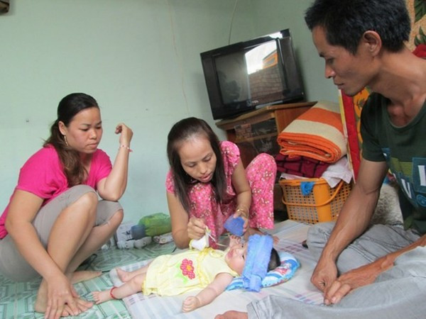 Anh Hậu bên gia đình của mình. Con gái anh chỉ mới 5 tháng tuổi và đã bị sốt suốt nhiều ngày nay. Ảnh: Lao Động Online. Anh Hậu bên gia đình của mình. Con gái anh chỉ mới 5 tháng tuổi và đã bị sốt suốt nhiều ngày nay. Ảnh: Lao Động Online