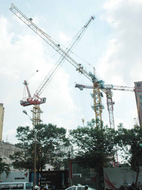 Những “cánh tay” dài của nhiều cần cẩu tại công trình xây dựng khách sạn trên đường Nguyễn Huệ, Q.1, TPHCM thi nhau “vươn” ra đường. Ảnh: Quang Phương