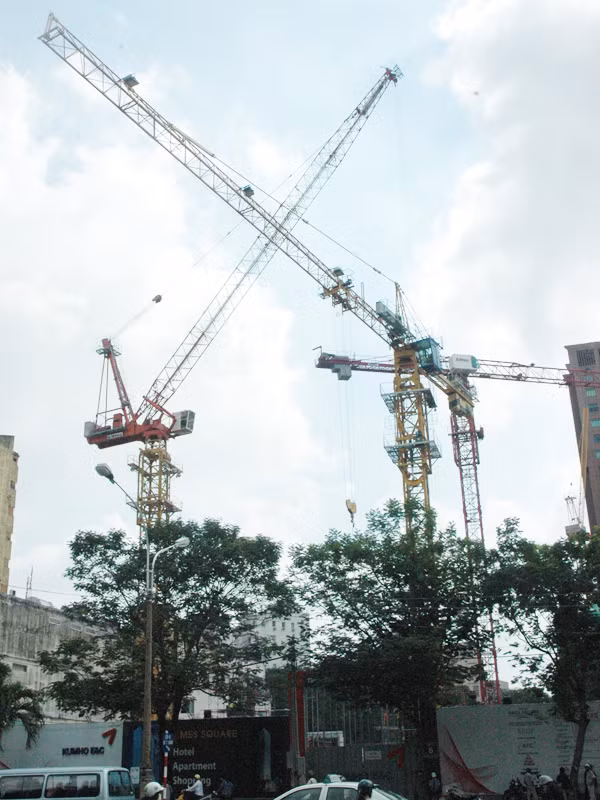 Những “cánh tay” dài của nhiều cần cẩu tại công trình xây dựng khách sạn trên đường Nguyễn Huệ, Q.1, TPHCM thi nhau “vươn” ra đường. Ảnh: Quang Phương