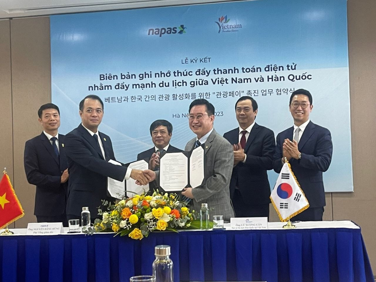 Ông Nguyễn Quang Hưng - Chủ tịch Công ty Cổ phần Thanh toán Quốc gia Việt Nam (NAPAS) và ông Lý Xương Căn - Đại sứ du lịch Việt Nam tại Hàn Quốc (từ trái qua) trao đổi biên bản ký kết