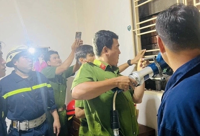 Đại úy Phan Công Hạnh trực tiếp cắt cửa sổ tạo không gian giải cứu nạn nhân từ tầng 3 phía sau căn nhà số 107 (Ảnh: Công an cung cấp).