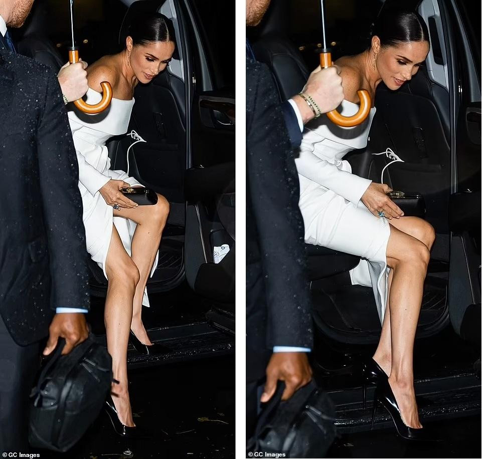 Trong khi chồng mặc lễ phục đen kết hợp áo sơ mi trắng thường thấy, Meghan mặc váy trắng sang trọng của Louis Vuitton. Người đẹp 41 tuổi búi tóc gọn, trang điểm tông nude. Phụ kiện đi kèm là ví cầm tay dạng hộp màu đen, bông tai dài bằng vàng và giày cao gót màu đen. Đáng chú ý nhất là chiếc nhẫn có mặt là ngọc lục bảo từng thuộc về Công nương Diana. Ảnh: Daily Mail.