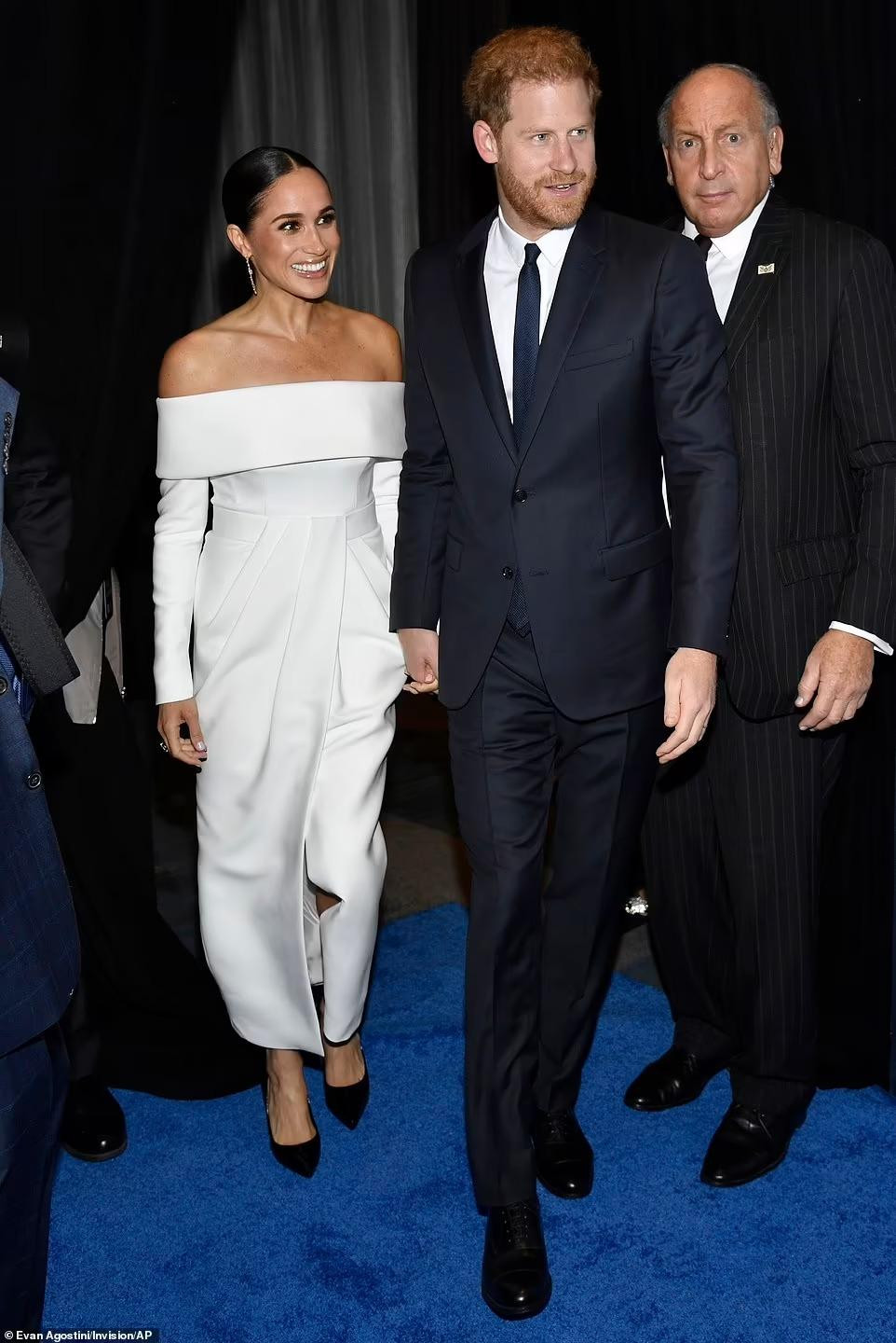 Harry và Meghan nắm chặt tay nhau, vui vẻ trước sự vây quanh của cánh phóng viên. Tuy vậy, họ từ chối trả lời các câu hỏi từ báo chí, cũng như phớt lờ những thắc mắc liên quan đến bộ phim tài liệu sắp ra mắt hay yêu cầu đưa ra thông điệp gửi tới Hoàng gia Anh. Ảnh: AP.