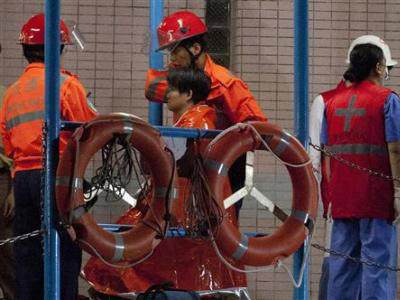 Các nhân viên cứu hộ đưa những người bị nạn lên bờ