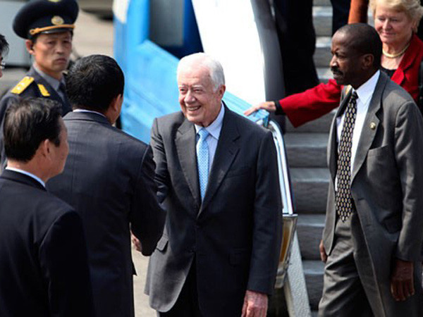 Cựu Tổng thống Mỹ Jimmy Carter (giữa) được chào đón tại Bình Nhưỡng hôm 26-4. Ông nói rằng, nhà lãnh đạo Triều Tiên Kim Jong-il muốn hội đàm trực tiếp với Tổng thống Hàn Quốc	Ảnh: AP