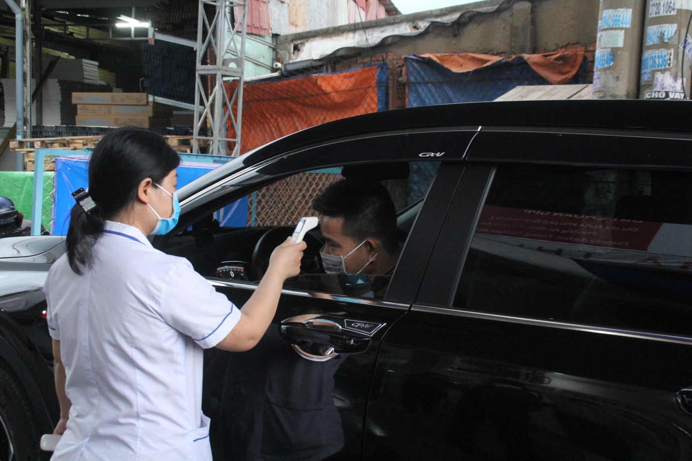 Nữ nhân viên y tế đo thân nhiệt đối với các cá nhân điều khiển phương tiện từ khu vực tiếp giáp đi vào địa phận TPHCM Nữ nhân viên y tế đo thân nhiệt đối với các cá nhân điều khiển phương tiện từ khu vực tiếp giáp đi vào địa phận TPHCM