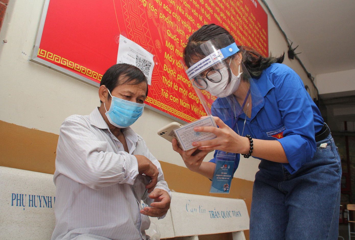 Lê Ngọc Minh Khuê hỗ trợ người dân tại điểm tiêm Trường THCS Trần Quốc Toản (TP. Thủ Đức)