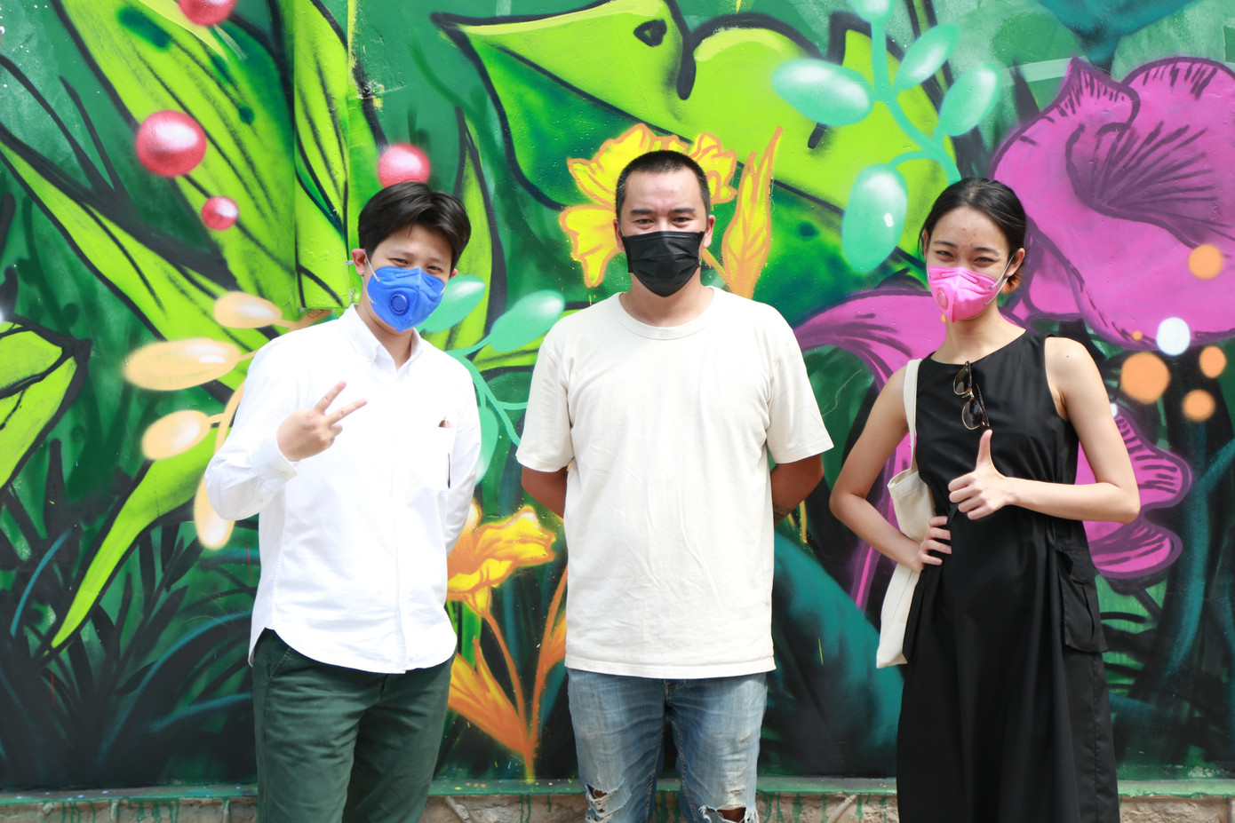 Người nghệ sĩ vẽ tranh đường phố lưu niệm cùng bạn bè bên tác phẩm của mình.