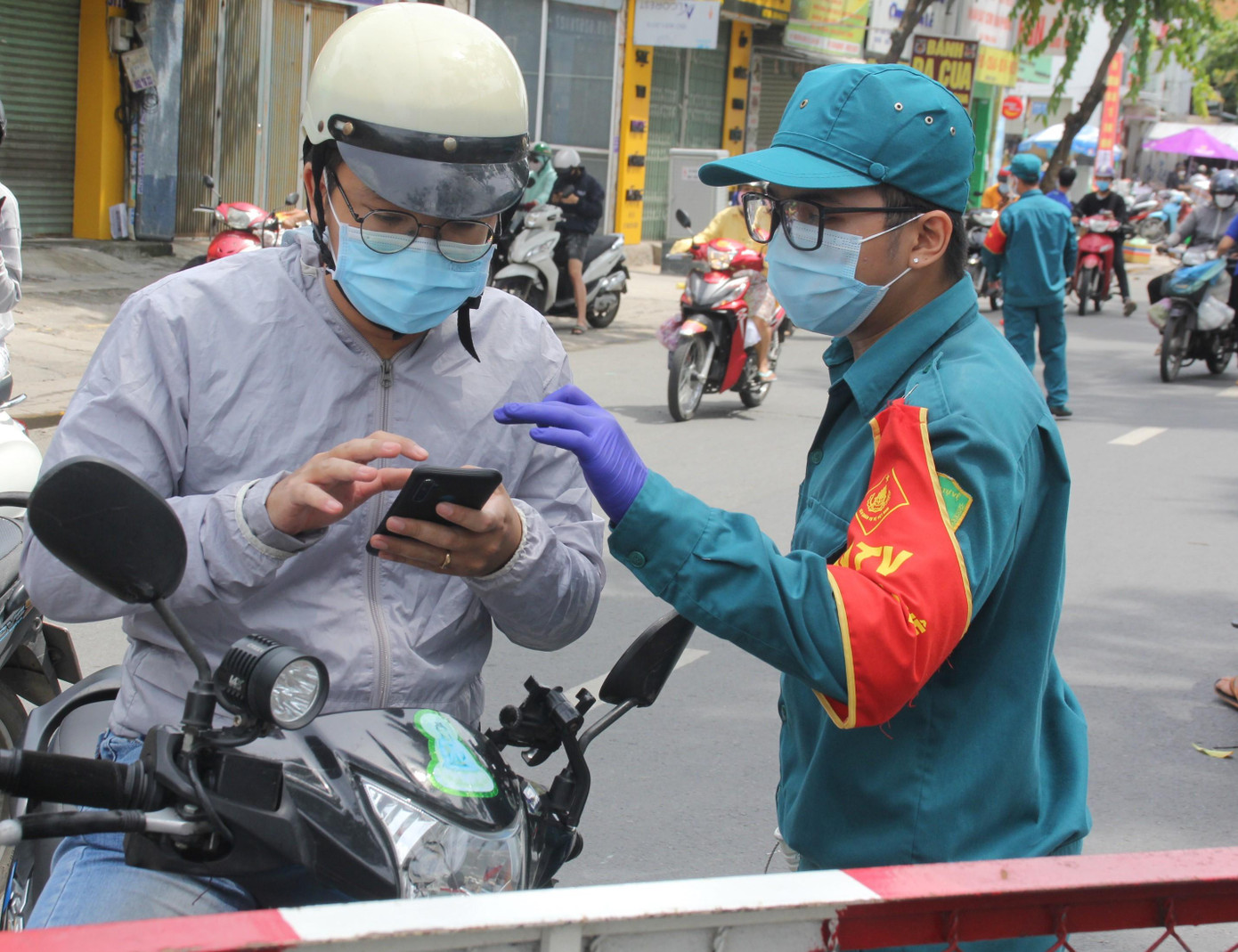 Tình nguyện viên hỗ trợ người dân tại chốt kiểm soát chân cầu vượt Nguyễn Thái Sơn