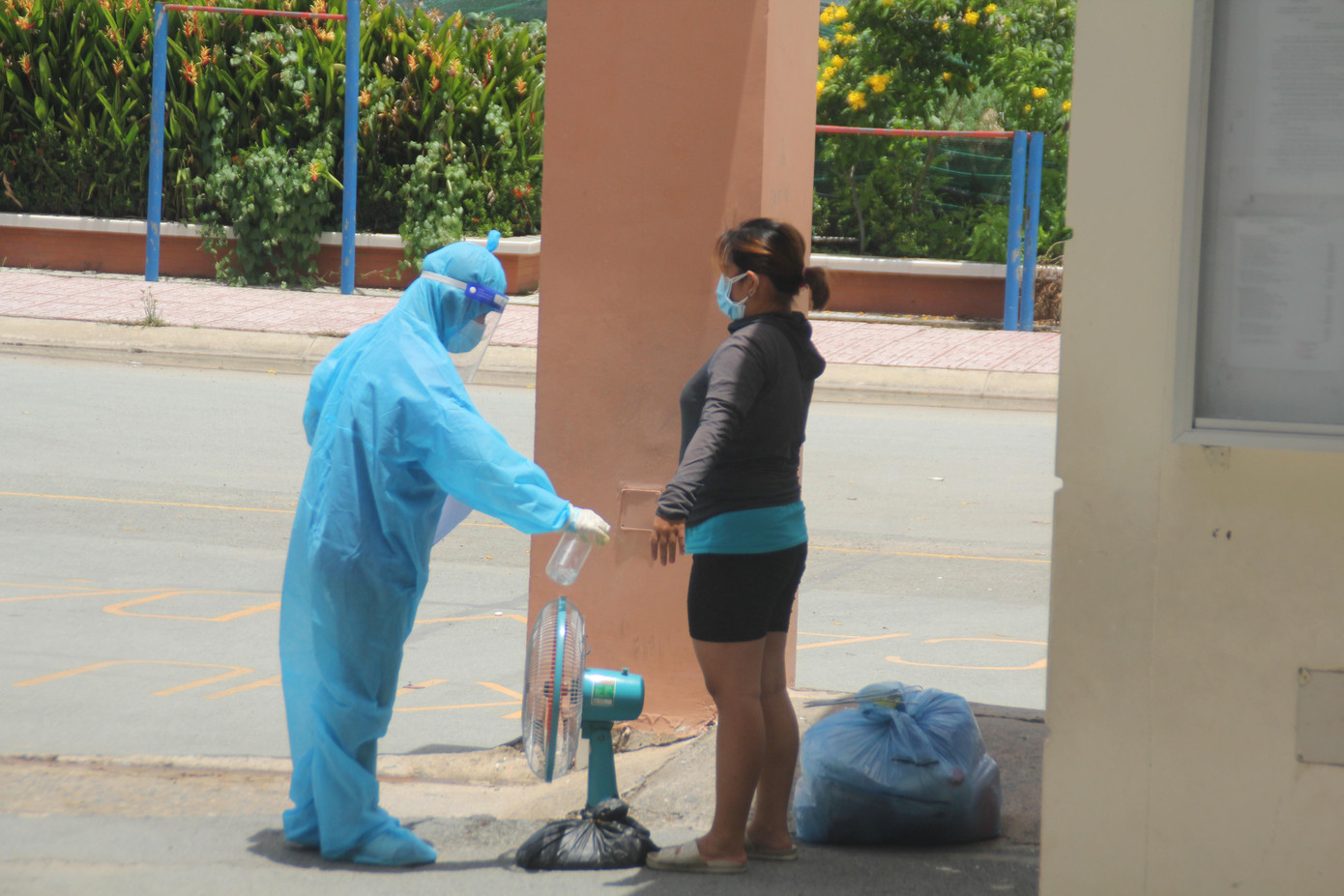 Tình nguyện viên sát khuẩn cho một người bệnh trước khi chị được đón về.