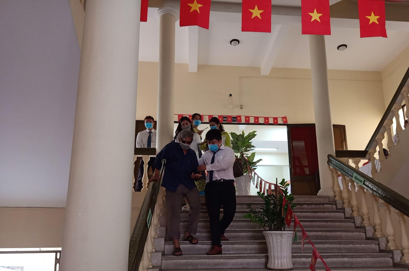 Bạn trẻ dìu đỡ những người yếu thế trong lúc tham gia bầu cử (Ảnh: Bến Hàm Tử)