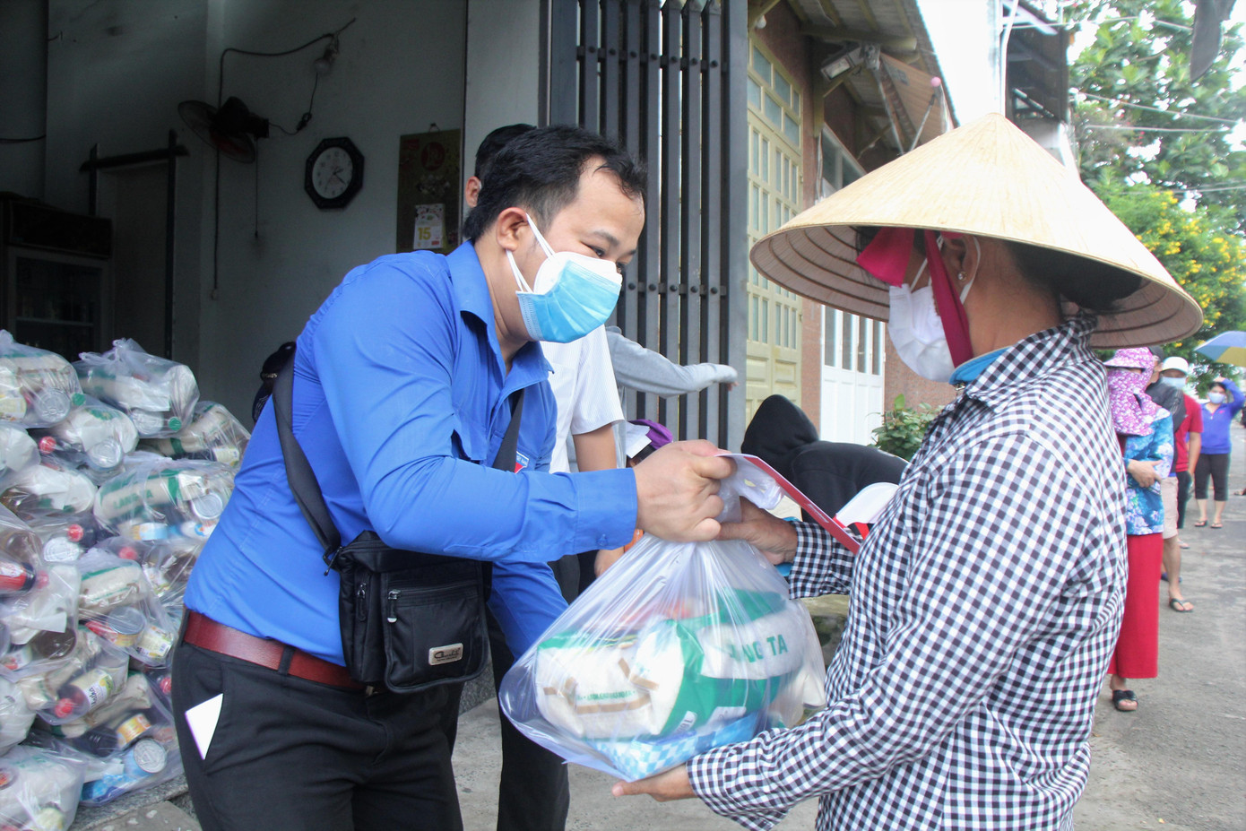 Anh Lương Văn Minh Tuấn, đại diện báo Tiền Phong trao túi quà an sinh của Công ty TNHH Hybrid Technologies Vietnam cho người dân Bình Tân