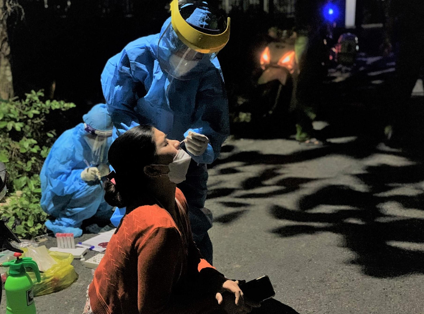 Các tình nguyện viên TPHCM và lực lượng y tế địa phương tiến hành "giải gộp" bóc tách F0 ngay trong đêm - Ảnh: Hoàng Trường