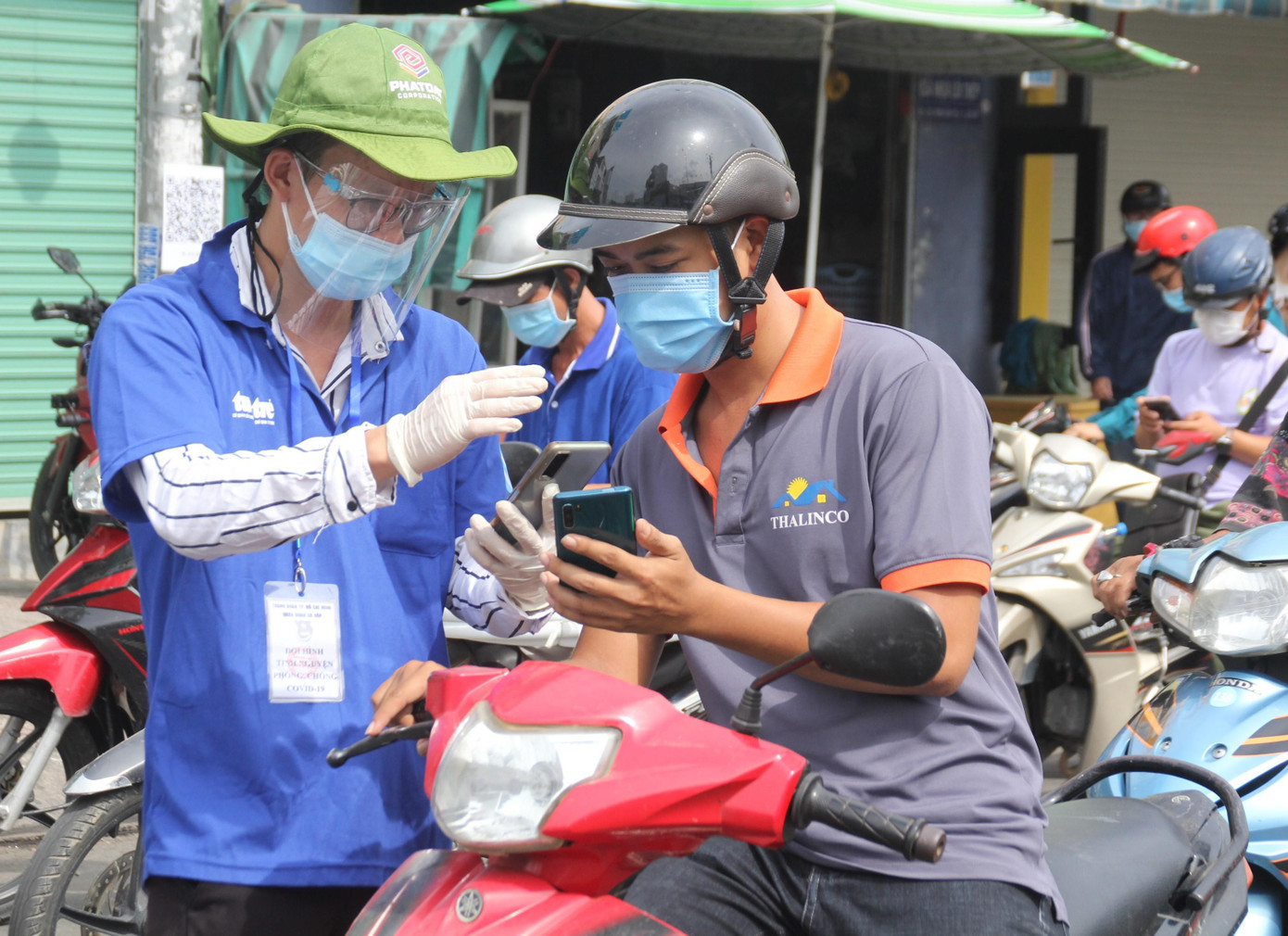 Các bạn trẻ chịu đựng nắng mưa để hỗ trợ lực lượng chức năng phân luồng, giúp người dân khai báo y tế mỗi khi ra - vào chốt kiểm soát trên địa bàn &quot;điểm nóng&quot; Gò Vấp