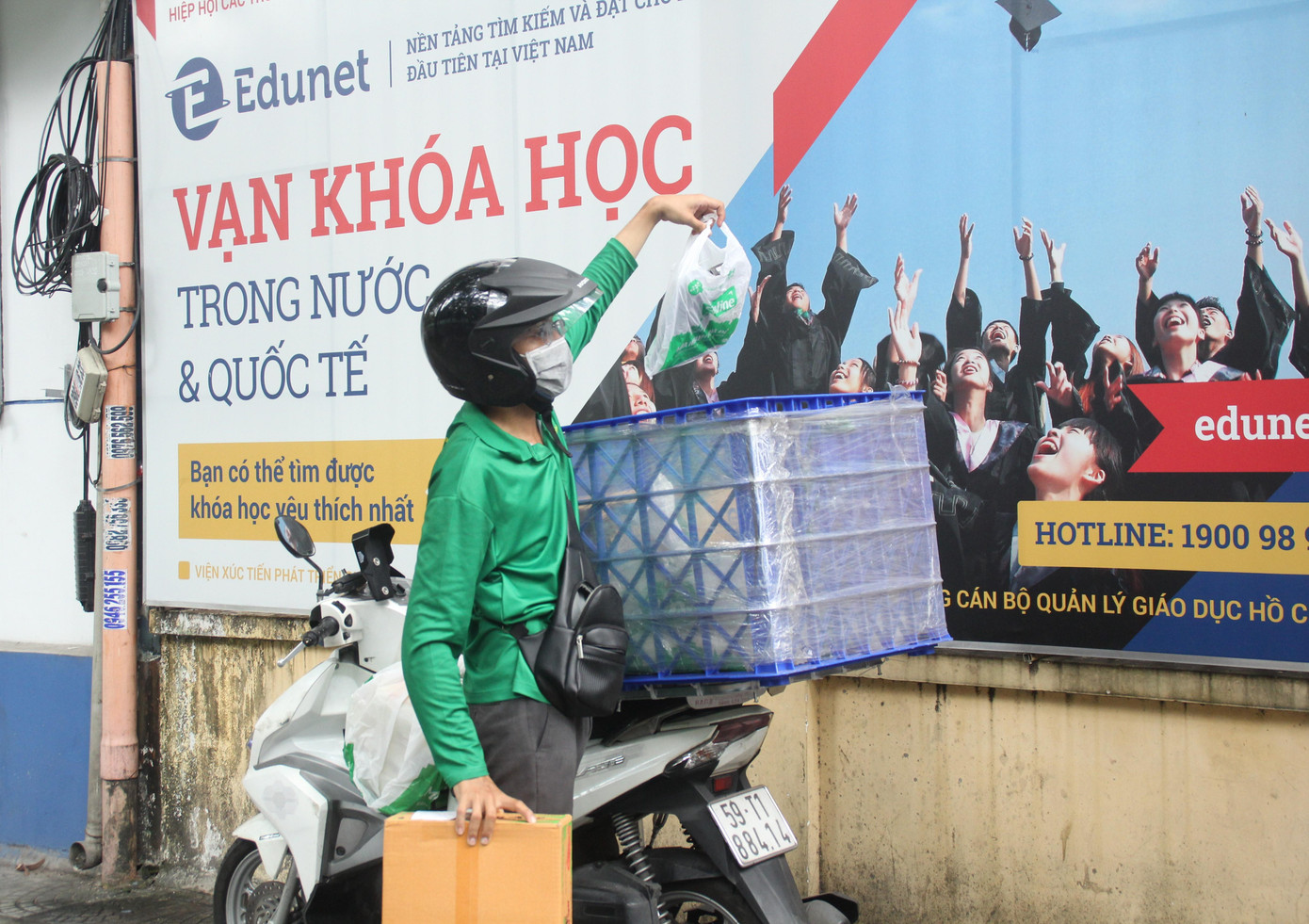 Tài xế giao hàng của Bách Hóa Xanh cho biết trong những ngày này, lượng hàng hóa anh ship cho khách tăng đột biến trước nhu cầu mua sắm online từ các đối tượng khách hàng. &quot;Đội shipper chúng tôi chạy liên tục, nhiều khi chạy suốt không kịp ăn uống&quot;, nam shipper trẻ tuổi nói. Sau khi giao thùng mì gói và túi đồ cho khách hàng tại một tòa nhà ở quận 1, shipper này nhanh chóng lao xe đi để chuyển đơn hàng tiếp theo cho khách.