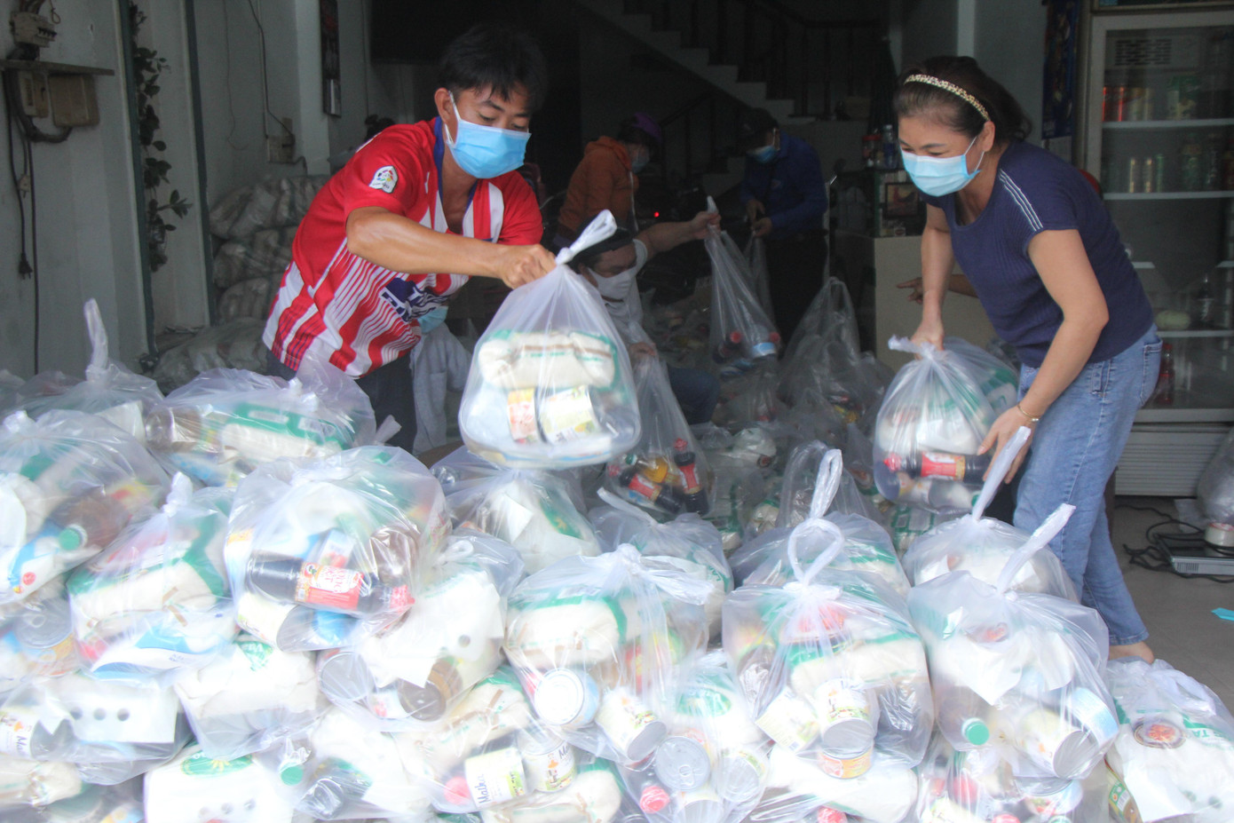 Tại TP.HCM, thông qua báo Tiền Phong, Công ty TNHH Hybrid Technologies Vietnam cũng đã gửi tặng 200 phần quà cho người dân tại quận Bình Tân. Trong đó có 184 phần trao cho bà con tại khu phố 1, phường Bình Hưng Hòa B và 16 phần trao cho bà con tại phường Bình Trị Đông B. Tổng kinh phí trao quà là 100 triệu đồng. Trong ảnh, đại diện Ban tổ chức và người dân địa phương hỗ trợ chuẩn bị các phần quà nhu yếu phẩm để chia sẻ với bà con.