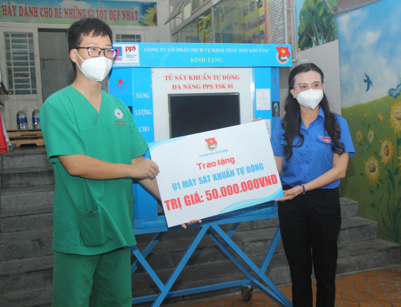 Chị Nguyễn Phạm Duy Trang, Trưởng ban Công tác thiếu nhi Trung ương Đoàn trao tặng máy sát khuẩn tự động cho các y bác sĩ nhằm hỗ trợ quá trình chống dịch tại bệnh viện.