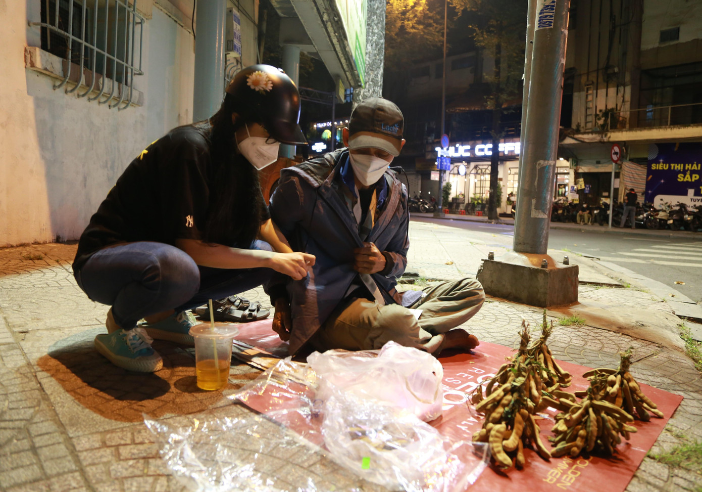 Phương chia sẻ với người đàn ông bán trái me ở góc vỉa hè trong đêm. Phương chia sẻ với người đàn ông bán trái me ở góc vỉa hè trong đêm.