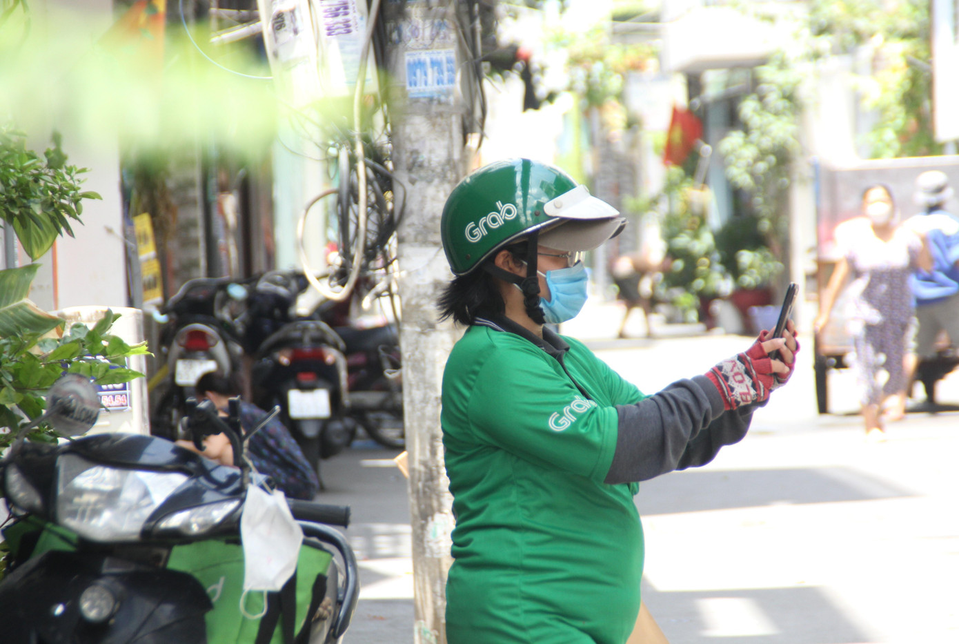 &quot;Mấy hôm nay tôi rất bận rộn với các đơn hàng vận chuyển hàng hóa và đi chợ thay cho khách&quot;, nữ shipper làm việc cho Grab nói. Theo bác tài nữ này, ngoài những đơn hàng thông thường, những ngày qua cô liên tục &quot;đi chợ thay&quot; khách thông qua các đơn hàng trên GrabMart.