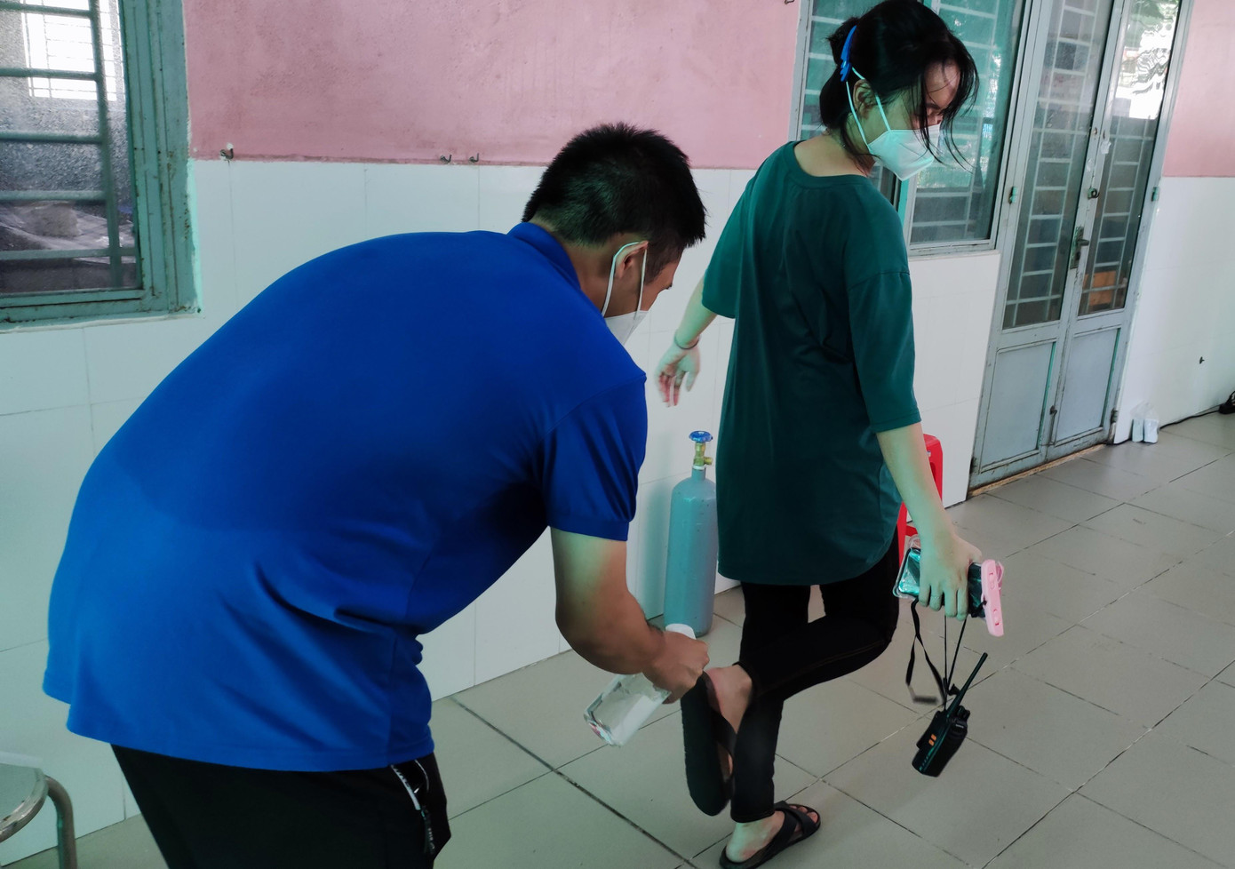 Sau mỗi hoạt động, các bạn trẻ luôn sát khuẩn, khử trùng kỹ càng trước khi bước vào &quot;vùng xanh&quot; an toàn của mình. Trong ảnh: Phạm Ngọc Hoàng xịt khuẩn cho nữ đồng đội Phạm Nguyễn Thanh Ngân. Mồ hôi còn ướt đẫm lưng khi cả hai vừa xong nhiệm vụ.