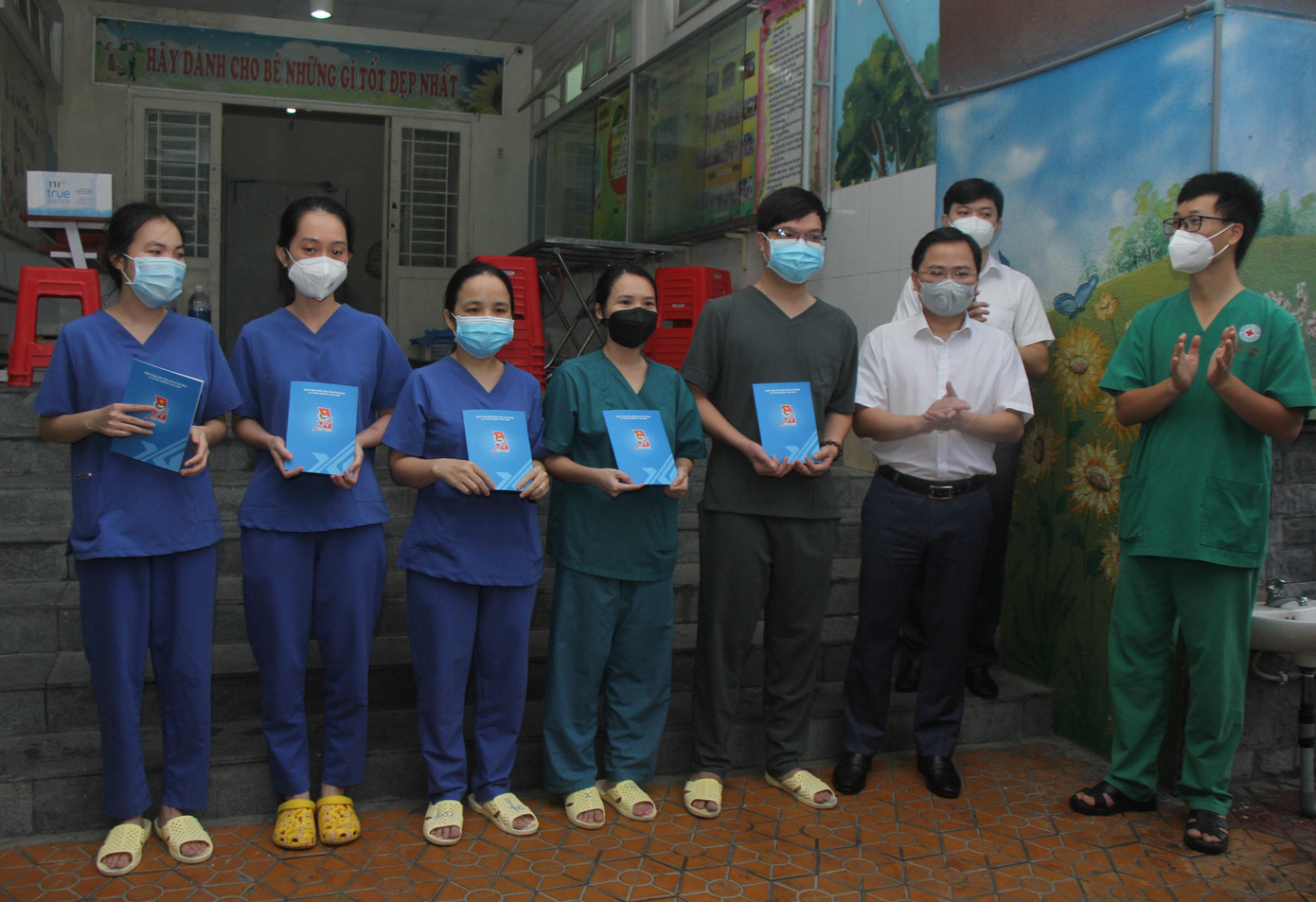 Bí thư thứ nhất Trung ương Đoàn Nguyễn Anh Tuấn trao phần quà động viên cho 5 thầy thuốc trẻ đang tham gia chống dịch tại Bệnh viện dã chiến Chung cư Bình Minh - Ảnh: Ngô Tùng