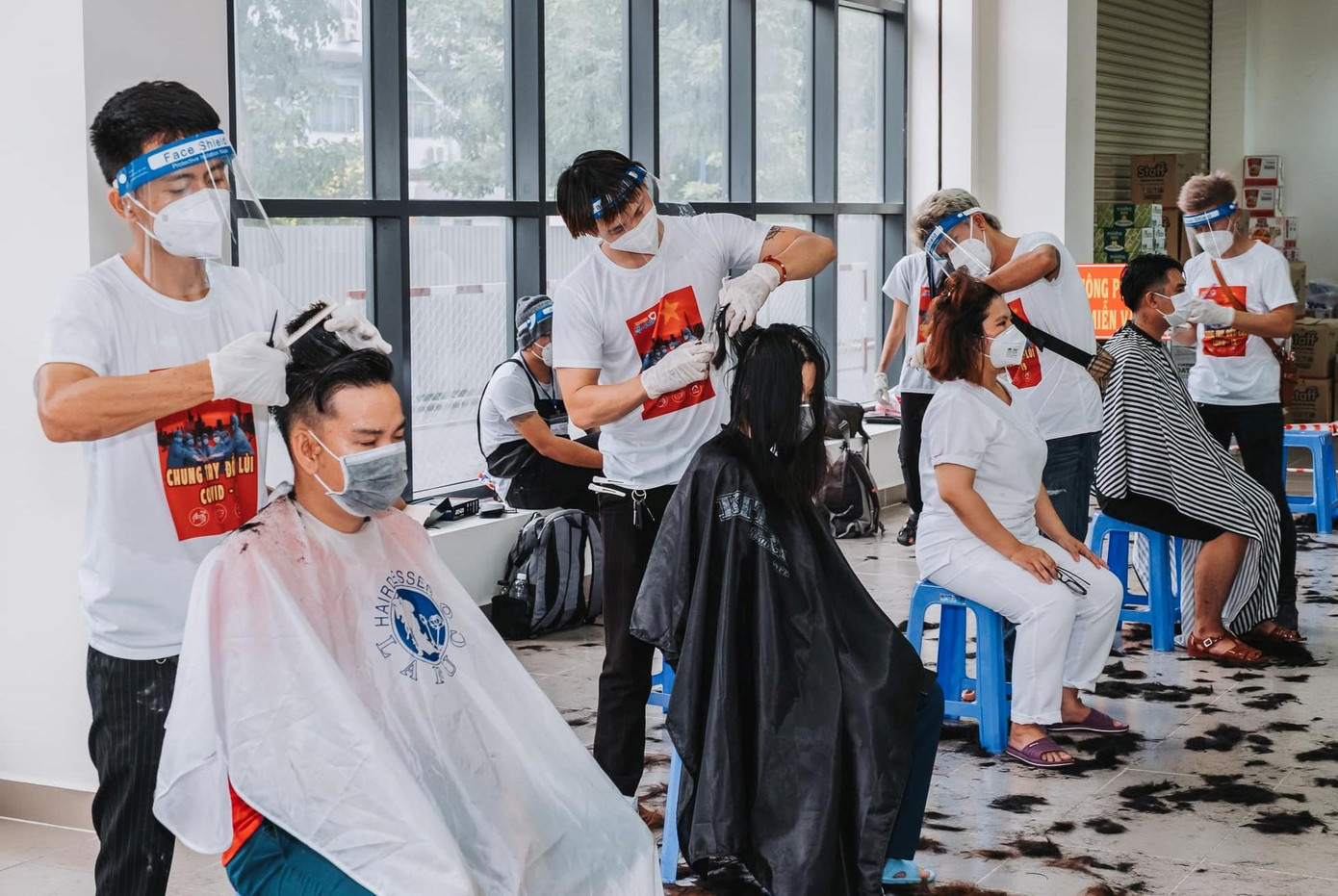 Các nghệ sỹ và thợ hớt tóc chuyên nghiệp cùng làm gọn mái đầu của y bác sỹ sau nhiều ngày họ không được cắt tỉa do kẹt công tác. (Ảnh: Neih Nguyen)