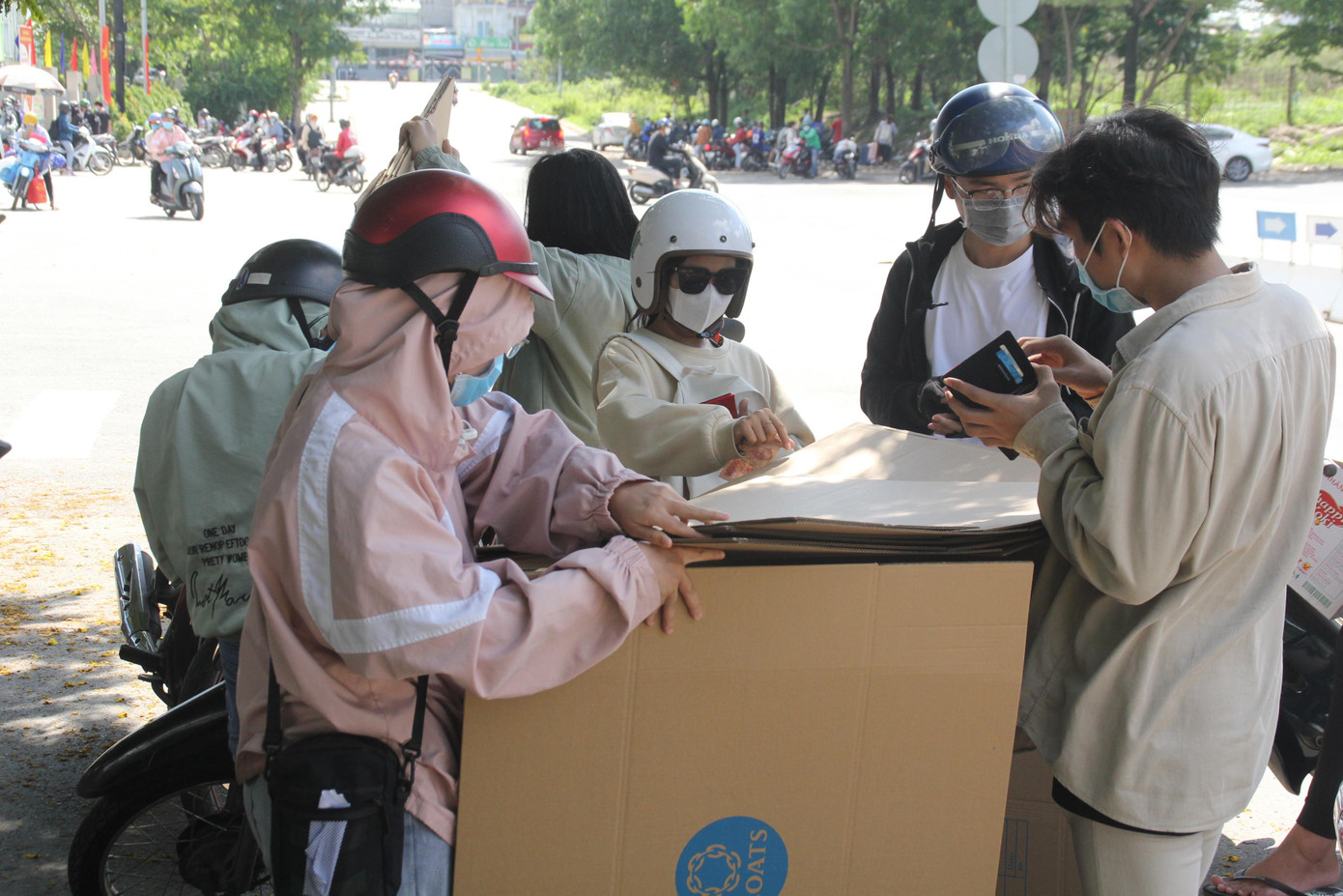 Sinh viên mua thùng các-tông bên ngoài cổng ký túc xá để đựng đồ đạc trước khi chuyển đi