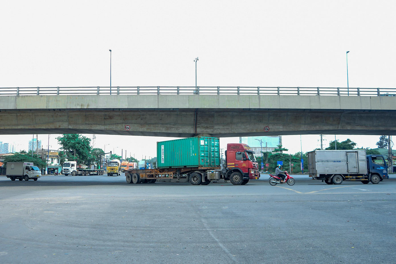 Xe máy chạy ngay trước đầu xe container tại vòng xoay