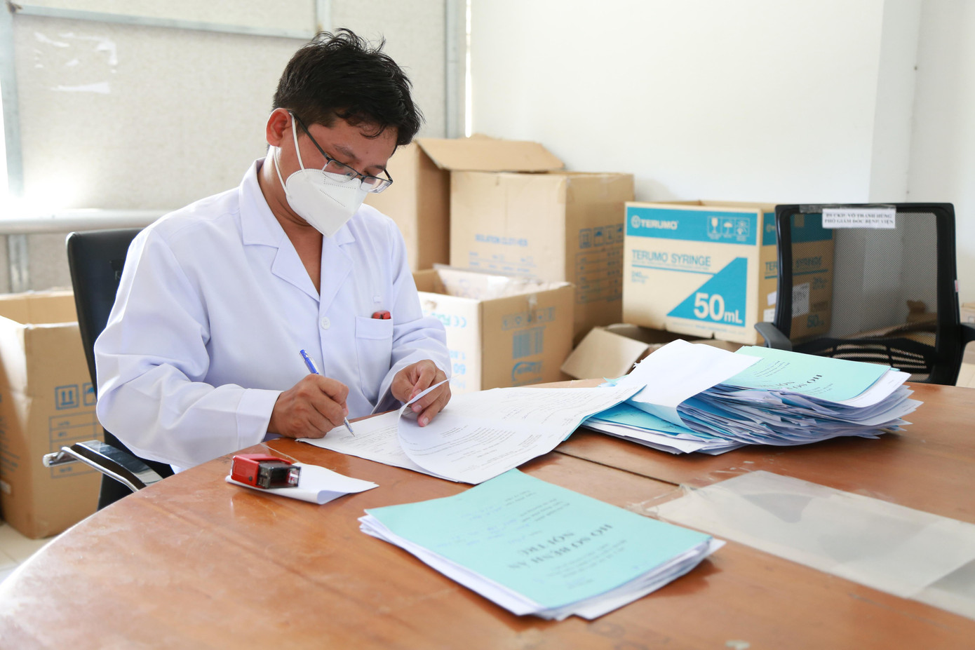 Bác sĩ Lý Quốc Công hoàn tất hồ sơ cho bệnh nhân COVID-19 xuất viện. Bác sĩ Lý Quốc Công hoàn tất hồ sơ cho bệnh nhân COVID-19 xuất viện.